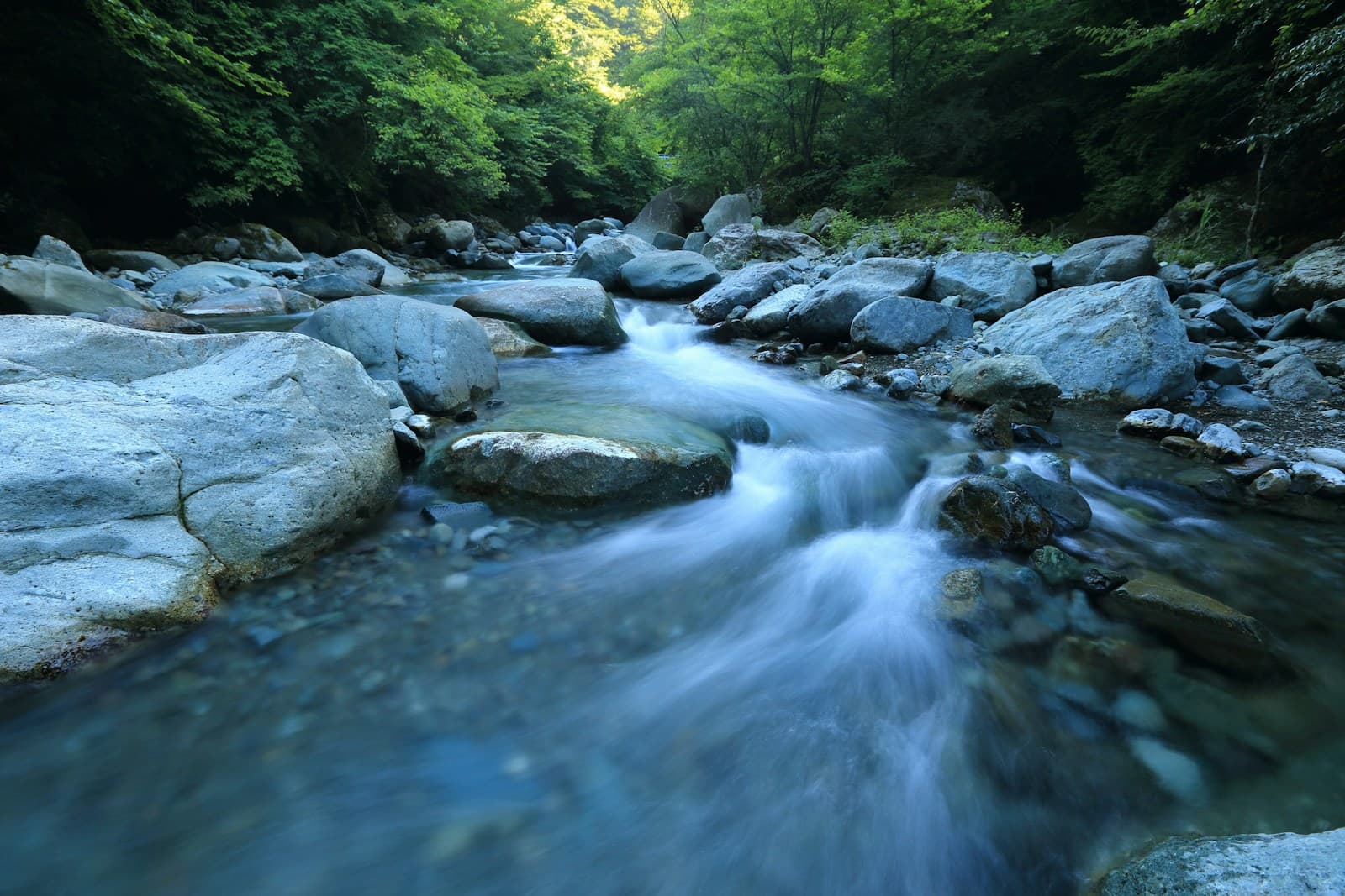 A stream flowing through shaded rocks; waterside-themed photography